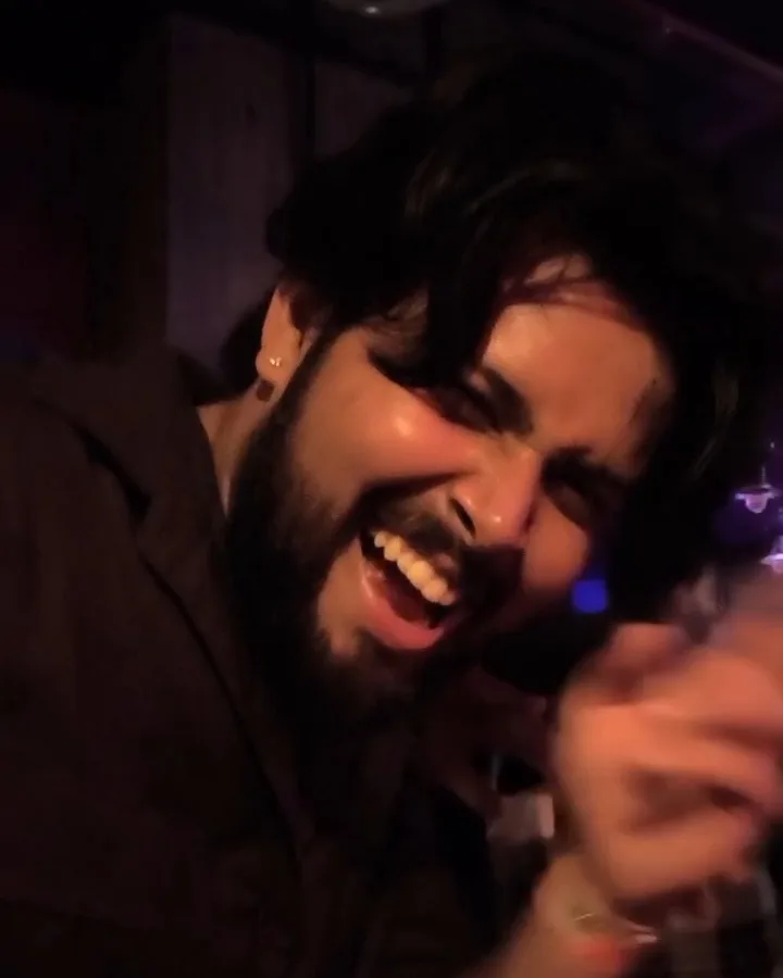 Yoginder laughing mid-dance in a dark, purple-lit club